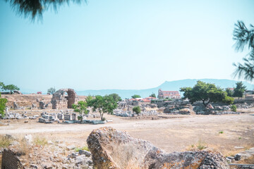 Wide view of ancient Corinth ruins with church and mountain in background