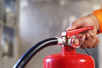Closeup of a male Hand Using Fire Extinguisher to Extinguish Fire  available in emergencies...