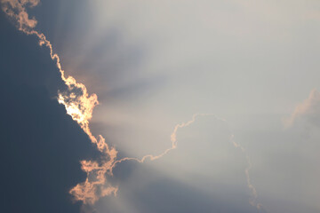 Heavenly Light: Witness the ethereal dance of light piercing through a cloudy sky, creating a...