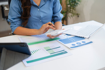 Business woman or financial data analysts working with alculator and laptop computers and data...