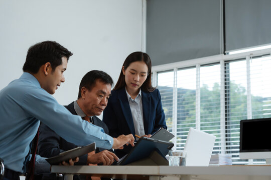 Consulting team discussing business progress, charts, and planning tasks with senior investor in office. Strategy update, teamwork, investor partnership concept.