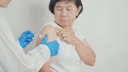 Elderly Woman with bandage after received vaccine. Vaccination and Immunization for Influenza, Herpes Zoster, Tetanus, Covid 19 booster, Dengue, Encephalitis, Rabies, Pneumococcal, IPD, RSV Vaccines