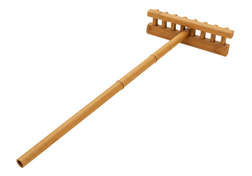 A bamboo rake rests against a black backdrop featuring a handle segmented by nodes and a toothed head