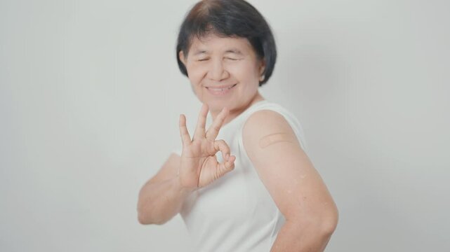 Elderly Woman with bandage after received vaccine. Vaccination and Immunization for Influenza, Herpes Zoster, Tetanus, Covid 19 booster, Dengue, Encephalitis, Rabies, Pneumococcal, IPD, RSV Vaccines