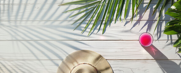 Obraz premium Flat Lay of Pink Summer Drink and Straw Hat on White Wooden Table with Palm Leaf Shadows Copy space
