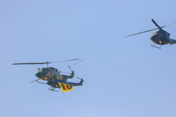 bell 212 rescue helicopter in camouflage colours and  black bell 412 helicopters are flying formation with national flag of sri lanka