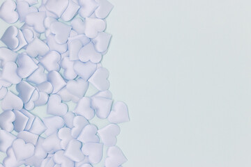 Textile hearts confetti on a blue background. Monochrome composition with place for text.