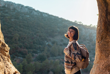 Portrait of happy female tourist in mountains. girl smiles. trekking and hiking. girl with backpack.