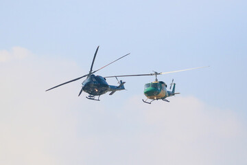 bell 212 rescue helicopter in camouflage colours and  black bell 412 helicopters are flying formation with national flag of sri lanka