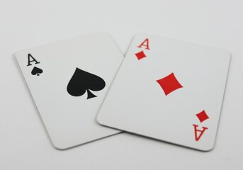 Two ace playing cards one of spade and one of diamond on a plain background