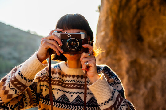 happy woman in the mountains with a camera in her hands. girl relaxing and taking photos in the mountains. trekking and hiking. girl with a camera.