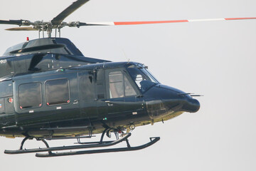 Black colour bell 412 helicopter in hover over an air field and ready for departure