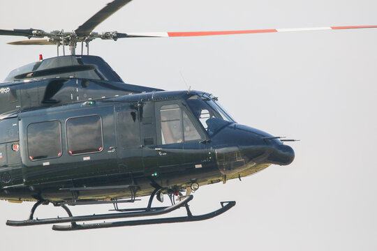Black colour bell 412 helicopter in hover over an air field and ready for departure