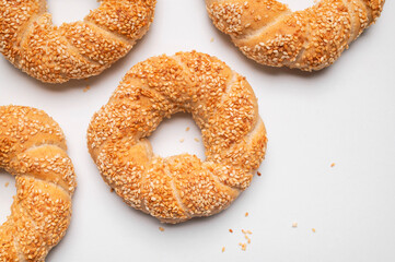 Simit or gevrek, round bagel with sesame seeds on white background top view. Traditional Turkish pastry, Istanbul street food. Delicious fresh homemade pastry, bakery product. Bagel mockup