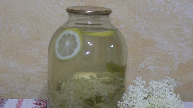 a jar with lemonade, jar of compote with lemon and elderflower, preservation of homemade compotes