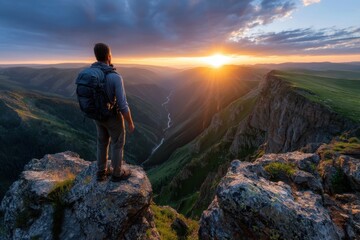 Fototapeta premium Hiker watches sunset over stunning valley with river in remote wilderness
