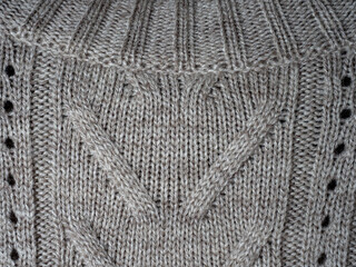 Neutral gray wool and cashmere knitwear with braid cable stitch knitted pattern, cozy winter textile background.