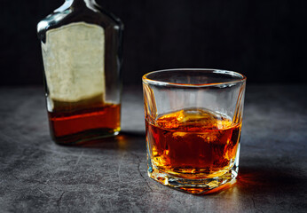 Strong alcohol drink and whiskey bottle Whisky in glass with ice, Whisky, bourbon or cognac. Hard...