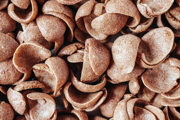Chocolate cereals corn flakes top view 
Cornflakes pile for breakfast, heap of brown choco cereals,...