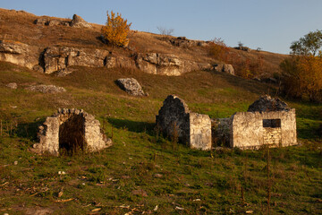 Ancient stone ruins, possibly a traditional dwelling or religious structure, are scattered across a...