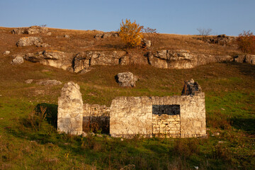 Ancient stone ruins, possibly a traditional dwelling or religious structure, are scattered across a...