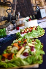 Decorative cold buffet platters with vegetables and grapes in rustic setting