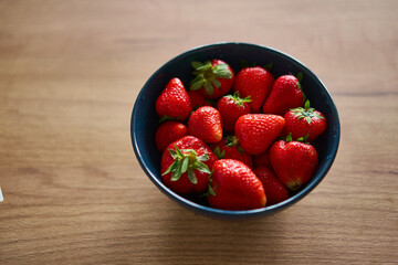 A beautifully vibrant bowl filled with fresh strawberries, showcasing their rich color, sweetness,...