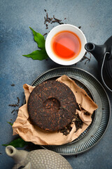 Tea ceremony. Composition of dry and brewed aromatic tea and a teapot for brewing. On a gray stone background. Top view.