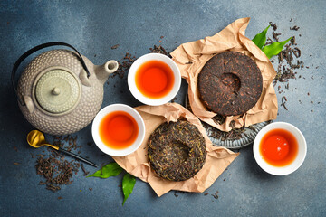 Tea ceremony. Composition of dry and brewed aromatic tea and a teapot for brewing. On a gray stone background. Top view.