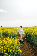 Walking through bright yellow flowers in a vast field on a sunny day