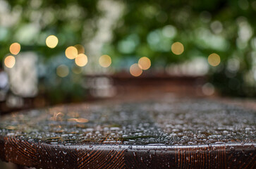A beautiful street restaurant with vintage wooden tables and umbrellas during the rain.