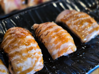 Grilled salmon nigiri made from belly cut with skin-on, glazed with teriyaki sauce and served on a...