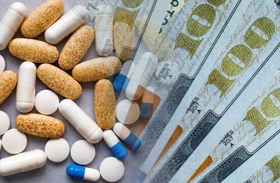 Medicine pills and capsules on a background of money. The concept of increasing prices for medical services, medicines, medical insurance