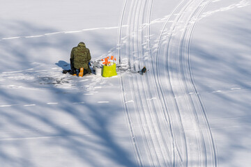 Ice Fisherman on Frozen Lake. Winter Outdoor Scene