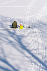 Ice Fisherman on Frozen Lake. Winter Outdoor Scene