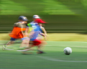 little four -year-old boys plays football at a sports school .Blur.