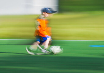 little four -year-old boy plays football at a sports school .Blur.