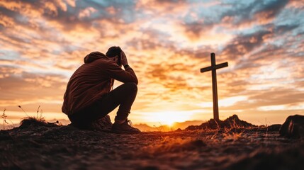 A contemplative silhouette of a person kneeling in prayer beside a cross, framed by a breathtaking sunset, conveying themes of spirituality and inner reflection.