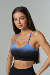 Fototapeta premium Close-up of a sporty woman showcasing fitness attire in a studio setting