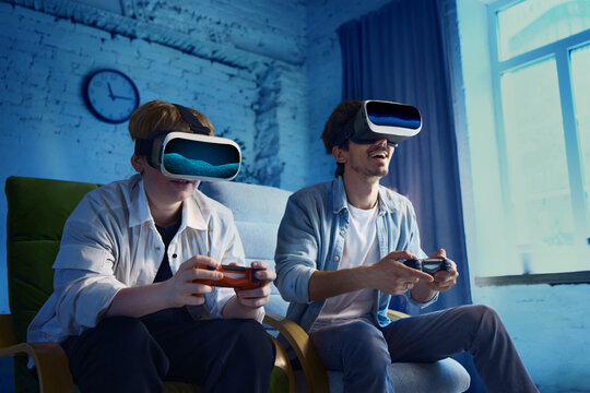 Father and son are having a captivating virtual reality gaming adventure indoors. This represents the idea of contemporary gaming and social engagement in digital spaces. - Powered by Adobe
