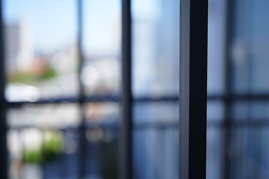 A Glimpse Through the Glass: A close-up perspective captures the interplay of light and shadow through a large window, inviting a sense of modern, urban minimalism. 