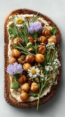 A toast with hummus and fried chickpeas  with wildflowers on the top 