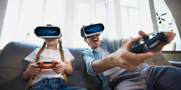A middle-aged father and his young daughter share a virtual reality gaming experience, full of enthusiasm and laughter. Concept of bonding through technology.