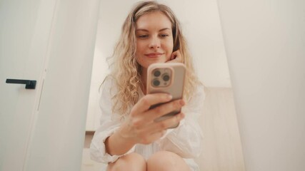 happy woman holding using mobile phone in hands spends time on social media reads news, businesswoman remote work from home business, hand typing message in smart phone. Blonde girl smiling face 4k - Powered by Adobe
