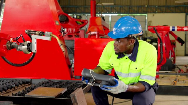 Worker or engineer operating remote switch controller to control robot machine in the factory