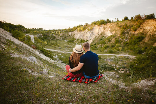 Loving couple embracing and admiring scenic landscape on a hilltop - Powered by Adobe