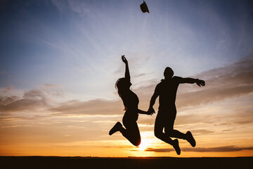Loving couple jumping at sunset, celebrating life and love