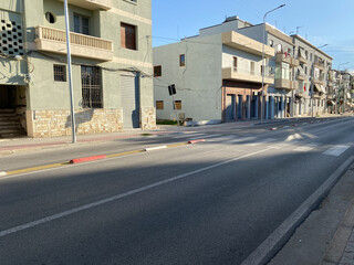Urban view of a small Albanian town with traditional houses, street, and power lines. Daily life, local architecture and greenery. Perfect for articles about Balkans or travel.