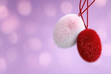 Furry red and white pom-poms hanging on soft background – suitable for festive mockups, holiday decor visuals or minimalist seasonal content.