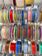 Multicolored ribbons in spools on a shelf